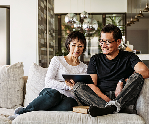 A couple reviewing a digital tablet.