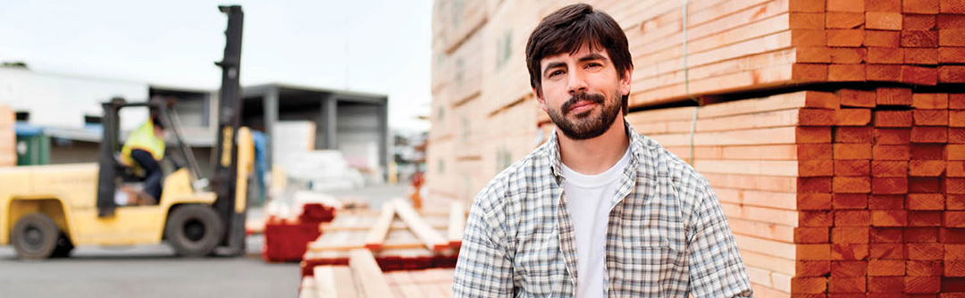 Man smiling at camera in front of construction site