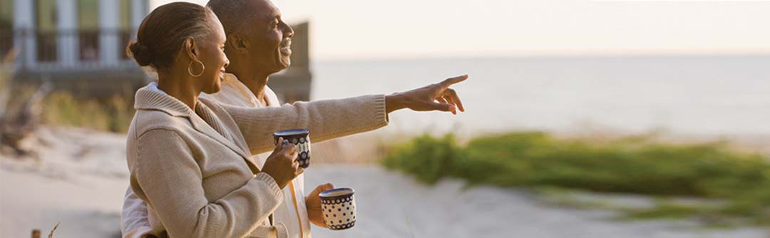 image of man and woman on the beach looking at the ocean