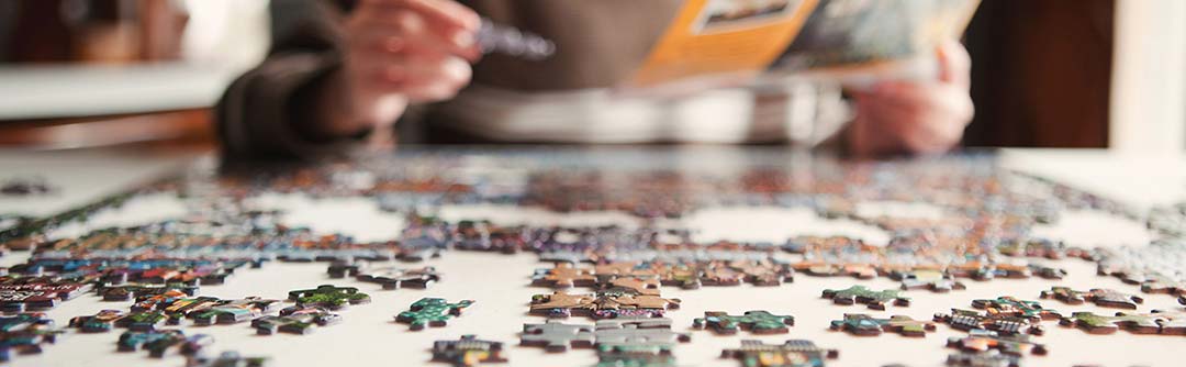 Closeup view of a pair of hands working on a jigsaw puzzle