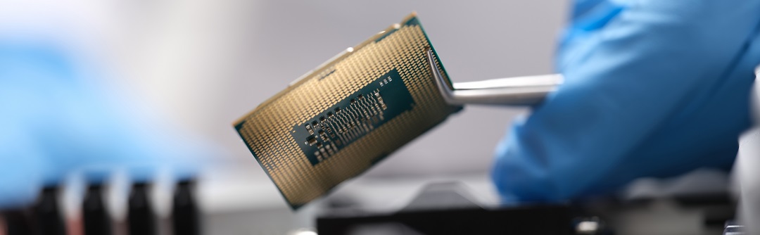 Engineer holding microprocessor from motherboard with tweezers