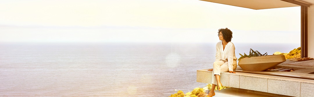 Woman sitting on a patio overlooking the ocean