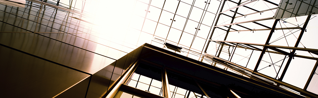 Upward view of the side of a skyscraper and construction scaffolding.