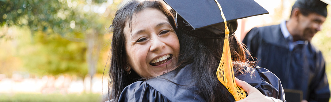 Female hugging female with graduation attire on