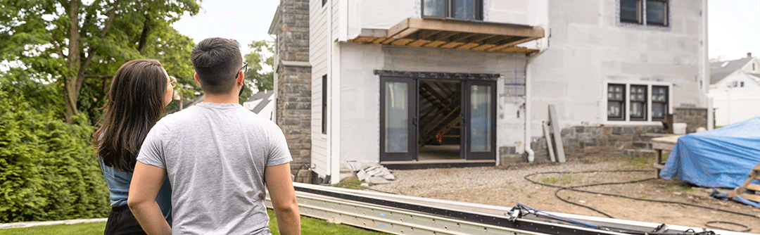 Man and woman looking at a house under construction