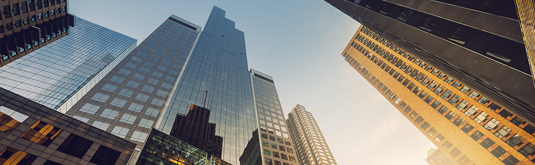 Upward view of towering skyscrapers at sunrise