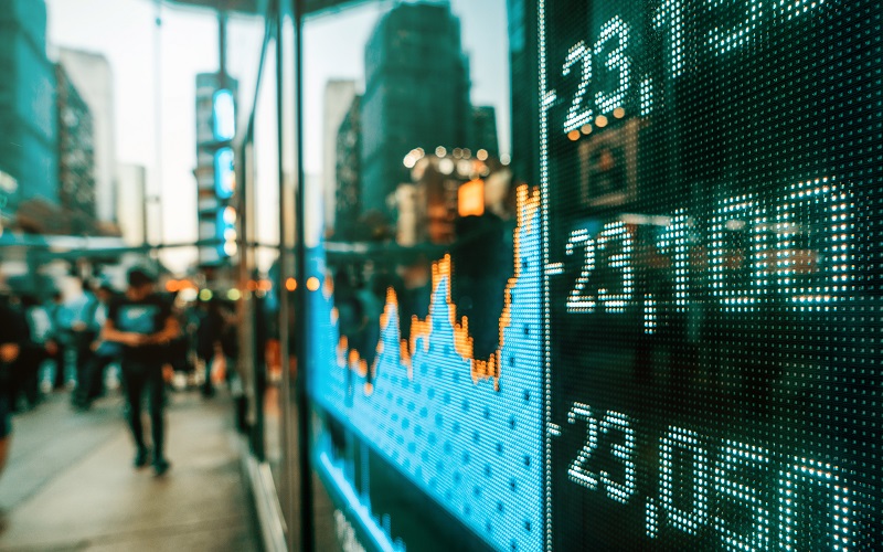 man on sidewalk outside window with stock market ticker