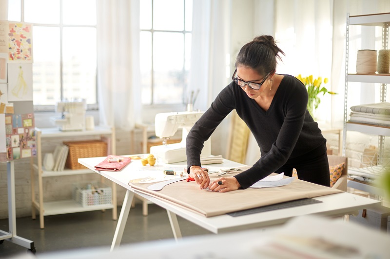 Woman working over a drafting table.