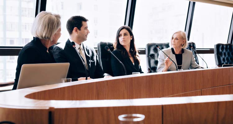 Four people seated at table having a business meeting