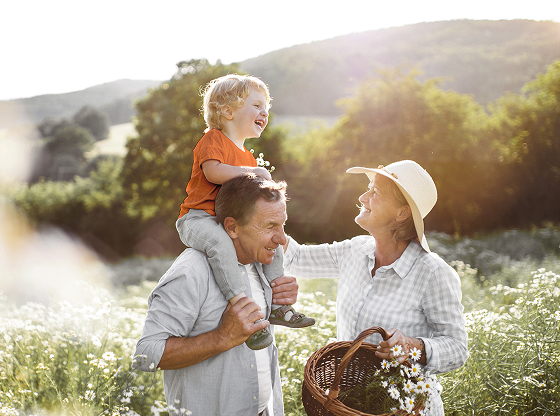 Grandfather and grandmother enjoying the outdoors with young grandchild.