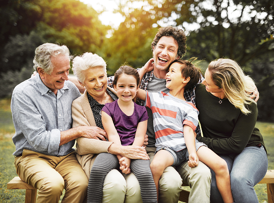 Multigenerational family laughing together outdoors.