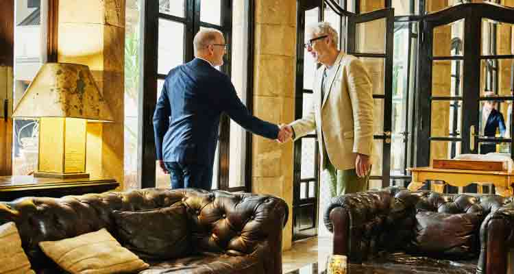 Two people greet each other with a handshake.