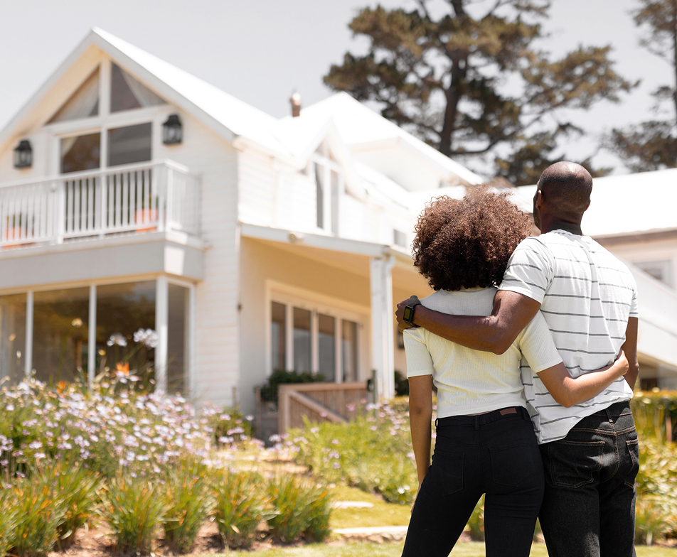 couple standing outside of a house