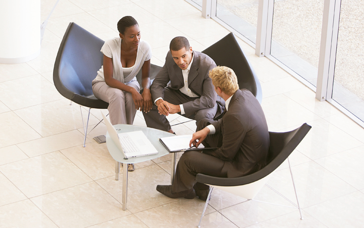 A couple sitting at the table with their financial advisor.