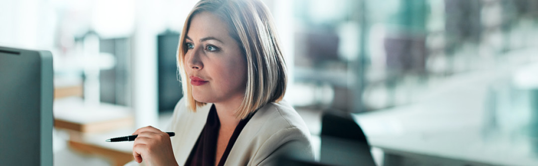 woman at her desk looking at her computer screen