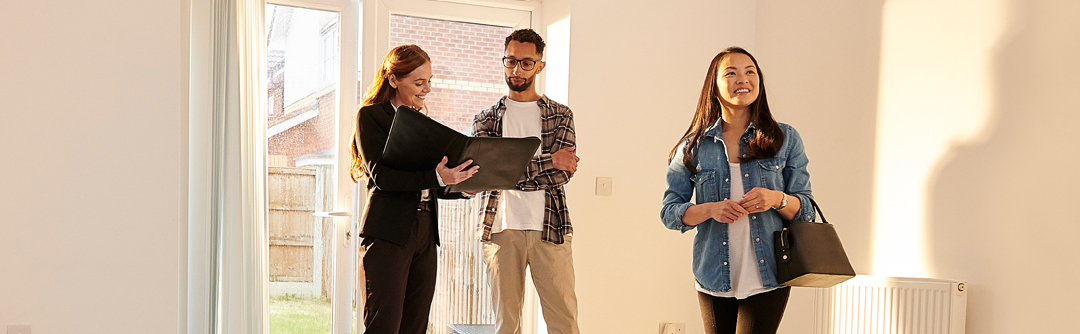 Woman and man along with realtor in new home