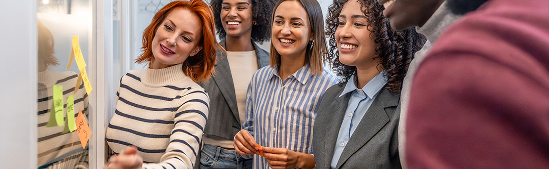 A group of young women smiling in a business setting.