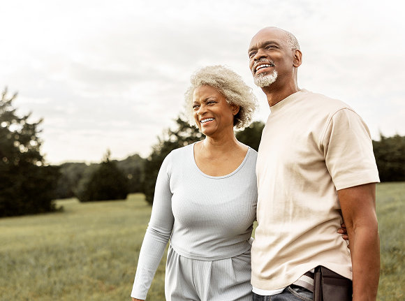 a couple standing in a field smiling